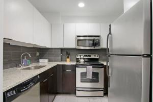 eine Küche mit einem Kühlschrank aus Edelstahl und einer Mikrowelle in der Unterkunft Cozy & Comfy Studio Apartment - Del Prado 418 in Chicago