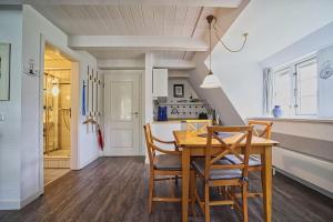 a dining room with a wooden table and chairs at Wohnung-Landwind in Süddorf