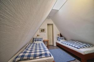 two beds in a room with a wall at Wohnung-Landwind in Süddorf