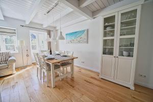 a kitchen and dining room with a table and chairs at Lycka-Hues in Norddorf