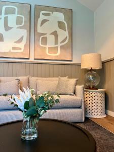 a living room with a couch and a table with flowers at Kangaroo Valley Golf and Country Retreat in Kangaroo Valley