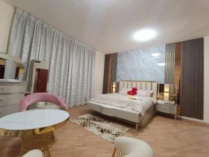 um quarto com uma cama, uma mesa e cadeiras em شقة فخمة وواسعة غرفتين luxury and big 2BR em Ajman