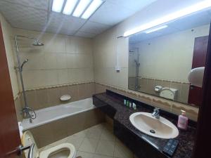 un bagno con lavandino, WC e specchio di شقة فخمة وواسعة غرفتين luxury and big 2BR ad Ajman Altre 13 foto