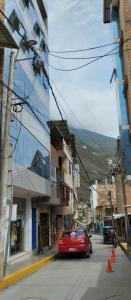 a red car parked on a street in a city at Hostal Panoramic in Churín