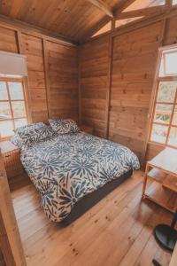 a bedroom with a bed in a wooden cabin at Eco Cabaña Guayacán Ráquira in Ráquira