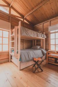 a bedroom with two bunk beds in a wooden cabin at Eco Cabaña Guayacán Ráquira in Ráquira