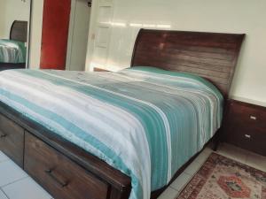 a bedroom with a bed with a wooden head board at Beautiful 2-Bedroom Near Airport - Powell's Main Road, Antigua in Carlisle