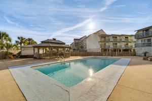格尔夫海岸Next to Gulf Shores Public Beach Condo with Pool!的毗邻部分建筑的带凉亭的游泳池