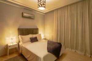 1 dormitorio con 1 cama blanca grande y mesita de noche en Résidence En-Nour - Gauthier, en Casablanca