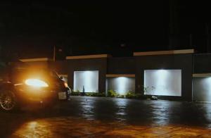 une voiture garée devant un bâtiment la nuit dans l'établissement Numdor Apartments By The Bond, à Port Harcourt