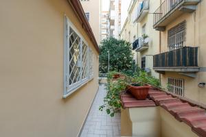 Un callejón con plantas en macetas al costado de un edificio. en Maison Morghen, en Nápoles