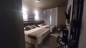 une chambre d'hôtel avec deux lits et un canapé dans l'établissement Maria's Hotel, à La Banda
