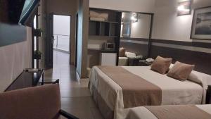 ein Hotelzimmer mit 2 Betten und einem Wohnzimmer in der Unterkunft Maria's Hotel in La Banda