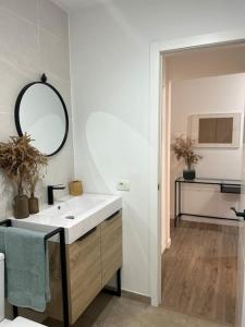 ein weißes Badezimmer mit einem Waschbecken und einem Spiegel in der Unterkunft Fisco Apartamento in Puertito de Güímar