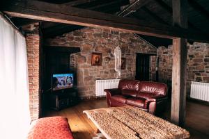 a living room with a leather couch and a tv at Casa Roma in Población de Abajo