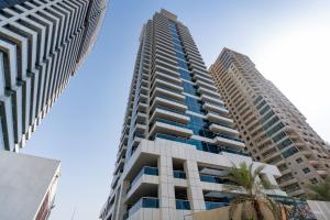 two tall buildings with palm trees in front of them at Marina Yacht Club Views - 3BR Modern Furnished in Dubai