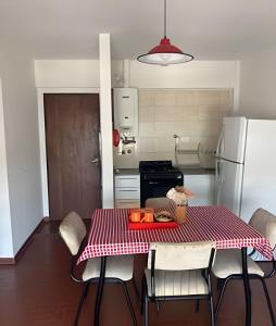 a kitchen with a table with a red and white table cloth at Depto "Phima" zona residencial in Rosario