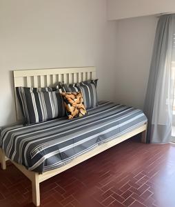 a bed with black and white pillows on it at Depto "Phima" zona residencial in Rosario