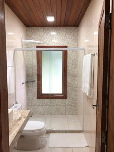y baño con aseo, lavabo y espejo. en Villa Uliana - Bangalôs VILLA en Domingos Martins