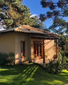 una pequeña casa con un porche en un patio en Villa Uliana - Bangalôs VILLA en Domingos Martins