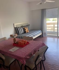 a room with a bed with a table with a red tray at Depto "Phima" zona residencial in Rosario