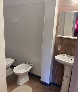 a white bathroom with two toilets and a sink at Depto "Phima" zona residencial in Rosario