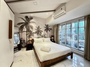 a bedroom with a bed and a palm tree mural at Luxury 2 BHK Tropical Apartment in Khar West in Mumbai