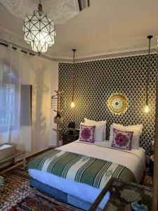 1 dormitorio con 1 cama grande con almohadas rosas en Riad Zahri, en Marrakech