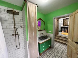 a green bathroom with a sink and a mirror at Habitación de 1870 in Santiago de Compostela