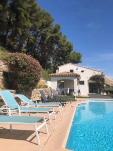 eine Gruppe Stühle und ein Pool in der Unterkunft Villa Les Pariades : 8 Prs, 4 ch, Piscine, Vue mer in Vallauris