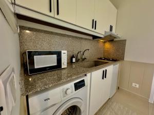 a kitchen with a washing machine and a sink at Nahr Ibrahim Suite 