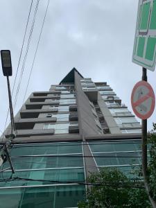 um edifício alto sem um sinal de estacionamento em frente em HOTEL BRIZO DEPARTAMENTO PARTICULAR em Salta