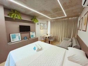 a bedroom with a bed and a couch and a tv at Setai Yacht Premium - By Almare Flats in João Pessoa