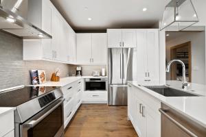 a kitchen with white cabinets and a stainless steel refrigerator at Riverfront Lodge, Unit 307 in Avon