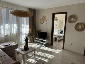 uma sala de estar com um sofá, uma televisão e um espelho em Samuil em Burgas
