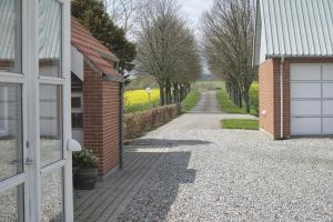 a driveway leading to a house with a brick building at Beautiful Home In Ebeltoft With 3 Bedrooms in Ebeltoft +8 photos