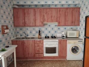 uma cozinha com armários de madeira e uma máquina de lavar e secar roupa em Apartamento Las Fuentes em Sierra de Fuentes