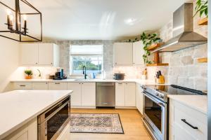a kitchen with white cabinets and a stone wall at Naples Duplex Home with Private Pool and Lanai! in Naples