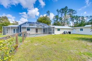 a white house with a fence and a yard at Naples Duplex Home with Private Pool and Lanai! in Naples