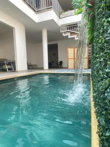 a swimming pool with a waterfall in a house at Hotel Boutique Iyarí in Palmira