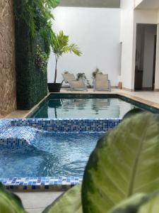 uma piscina com duas cadeiras e uma piscina em Hotel Boutique Iyarí em Palmira