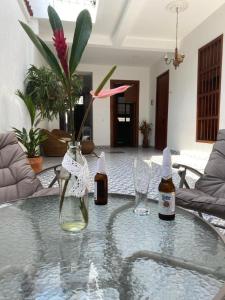 a glass table with two bottles and glasses on it at Hotel Boutique Iyarí in Palmira
