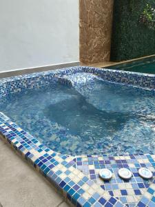 a swimming pool with blue and white tiles at Hotel Boutique Iyarí in Palmira