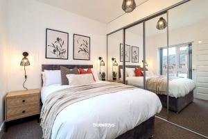 a bedroom with a large bed and a mirror at Kempthorne House by Truestays - NEW Entire House near Alton Towers in Etruria