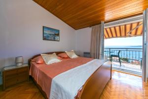 a bedroom with a bed with a view of the ocean at Guest house Lenka in Brela