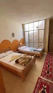 1 dormitorio con 2 camas y ventana en Dana star en Ḑānā