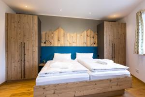 a bedroom with a large bed with wooden cabinets at LELA Apartments Chiemsee in Bernau am Chiemsee
