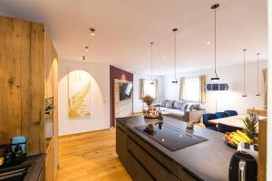 een keuken en een woonkamer met een bank en een tafel bij LELA Apartments Chiemsee in Bernau am Chiemsee