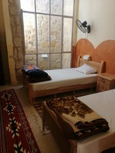 1 dormitorio con 2 camas y ventana en Dana star en Ḑānā