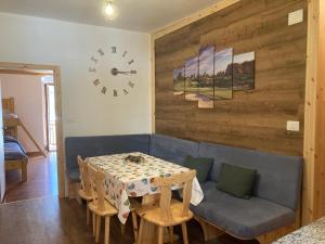 a dining room with a table and a clock on the wall at Casa vacanza Emi in Bocenago +6 photos